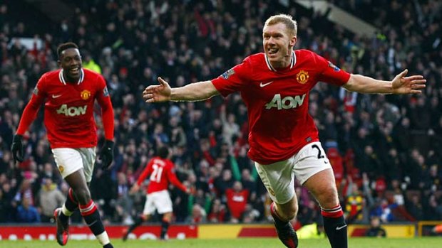 Manchester United's Paul Scholes celebrates scoring against Bolton Wanderers at Old Trafford, as teammate Danny Welbeck looks on.
