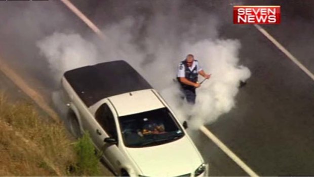 Smoke pours out the back of the ute after it comes to a halt.