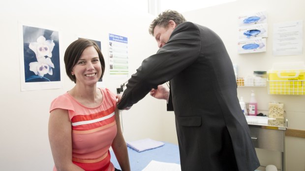 ACT Medicare Local Chair, Dr Martin Liedvogel gives Emma Kennedy a flu shot in his Fisher practice. 