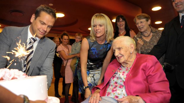 Lachlan Murdoch and sister Elisabeth present their grandmother, Dame Elisabeth, with her birthday cake at celebrations at the Melbourne Recital Centre last night.