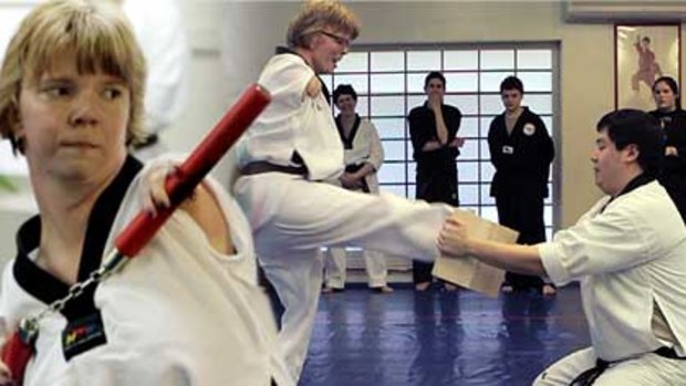 Black belt hopeful Sheila Radziewicz  runs through her numchuk and board-breaking exercises at her taekwondo class in Peabody.