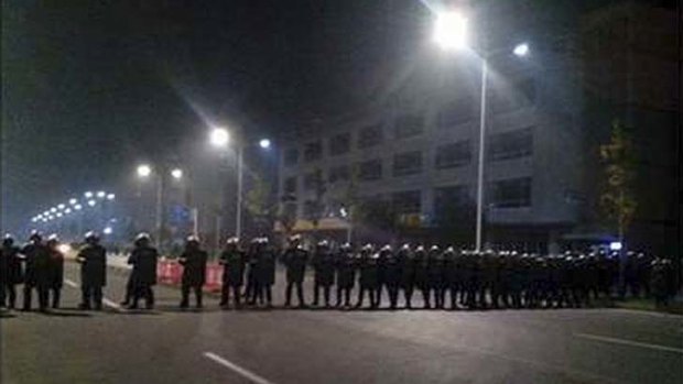 Police in anti-riot suits cordon off a road near Foxconn's plant in Taiyuan.