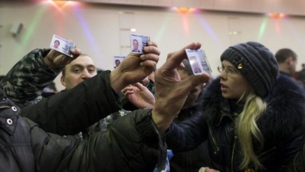 Protesters inspect parliament members' ID at the parliament building in Donetsk.