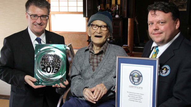 Jiroemon Kimura poses with Guinness World Records representatives Craig Glenday, right, and Frank Foley after Kimura was presented with the certificate of the world's oldest living man on October 15.