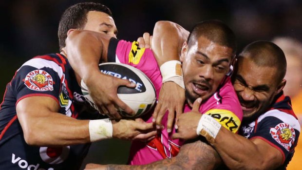 No contest: Panthers second-rower Sika Manu is tackled by Warriors players on Saturday.