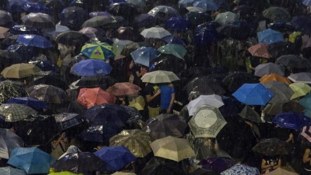 Pro-democracy protestors use umbrellas to shield themselves from heavy rain in Hong Kong.