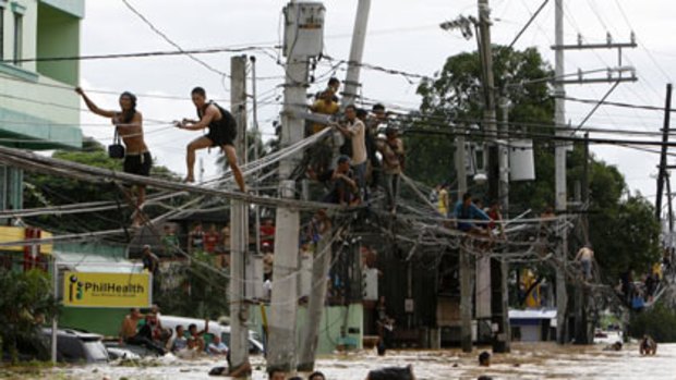 Philippines residents go to all lengths to escape neck-deep flood waters.