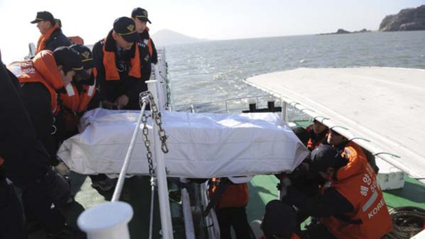 Casualties ... members of the Korea Coast Guard carry the body of a civilian killed in Tuesday's bombardment by North Korea.