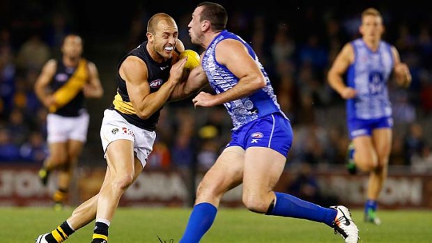 Matt Thomas of the Tigers and Todd Goldstein of the Kangaroos fight for the ball.