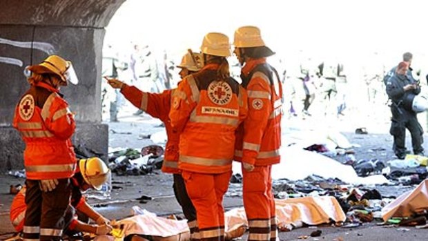 Rescue workers stand beside casualties after the stampede.
