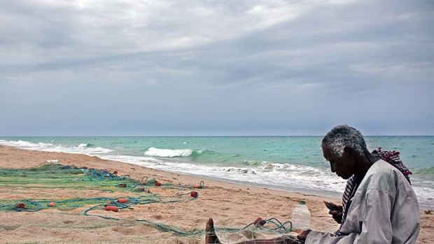 A fisherman tends his nets at Jebel Sifah on the Omani coast.