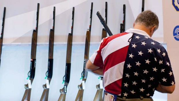 A man examines shotguns at a National Rifle Association exhibition in Missouri.