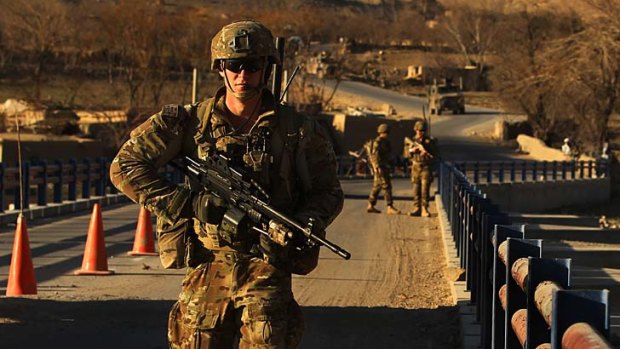 Vigilant: Australian soldiers patrol and search the Puza bridge in Oruzgan province for improvised explosive devices after an insurgent was arrested there the previous night with explosives.