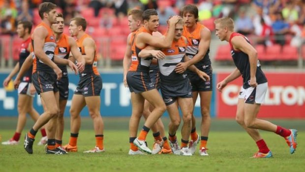 Adam Treloar is congratulated by his team mates after kicking a goal against the Melbourne Demons.