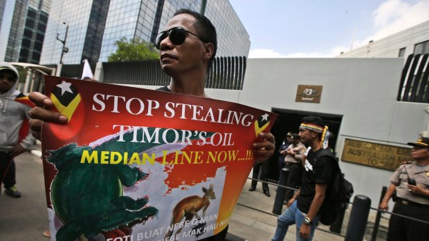 A protester holds a poster during a rally outside the Australian Embassy in Jakarta to  show  support for  Timor Leste in the dispute with Australia over oil and gas revenue-sharing.