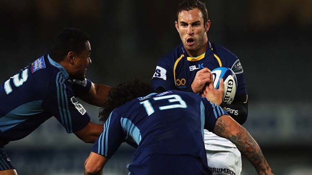 Tough rooster: The Brumbies' Nic White prepares to soak up another hit from the Blues' Rene Ranger on Saturday night.