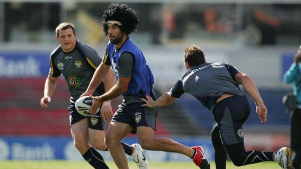 Big wig .. Cameron Smith, wearing an Afro, looks to pass at Kangaroos’ training in Melbourne yesterday as Brett  Morris, left, and a teammate close in on the Storm captain.