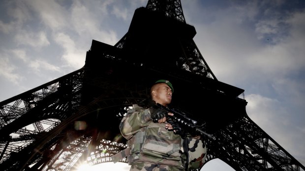 Armed military patrol the Eiffel Tower.