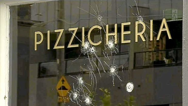 Bullet holes pierce the window of the Woodstock Pizzicheria on Lygon Street in October 2013.