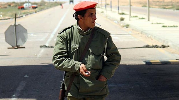 A Libyan soldier guards a checkpoint between Sirte and Tripoli.