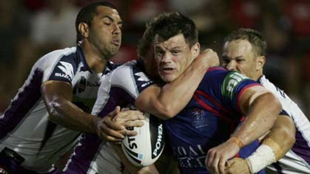 Castle invaded...Newcastle prop Ben Cross is wrapped up by the Melbourne Storm defence while inset, Knights forward Corey Paterson is held in an even tighter grip.