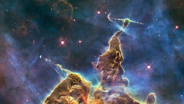 A Hubble space telescope image of a pillar of gas and dust in the Carina Nebula, 7500 light-years from Earth. Such  intersellar clouds might shelter microbes from cosmic rays that are deposited on passing planets.
