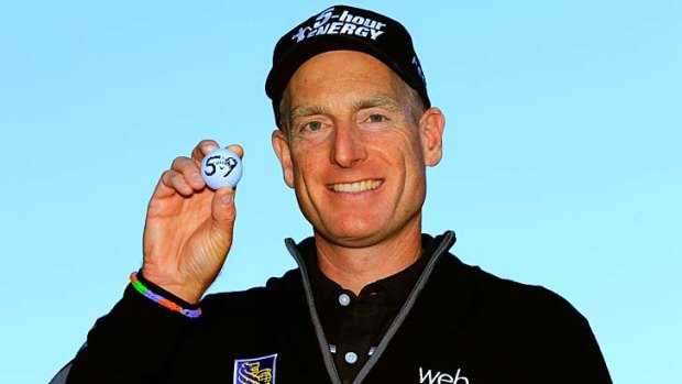 Jim Furyk holds up his ball with a '59' on it after shooting a 12 under round of 59.