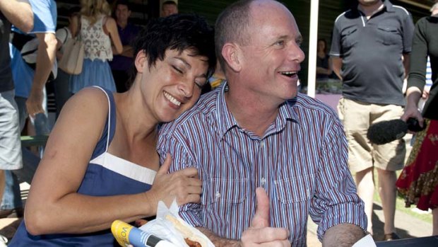 Campbell Newman and Lisa Newman enjoy a sausage sizzle after casting their votes for the Queensland State Election.