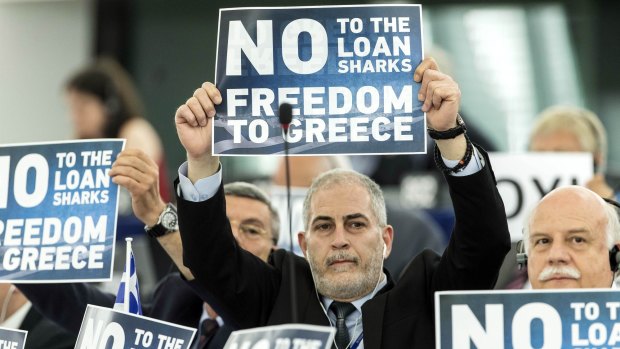 Far-right EU Parliament members display posters before Greek Prime Minister Alexis Tsipras delivers his speech at the European Parliament in Strasbourg, eastern France.