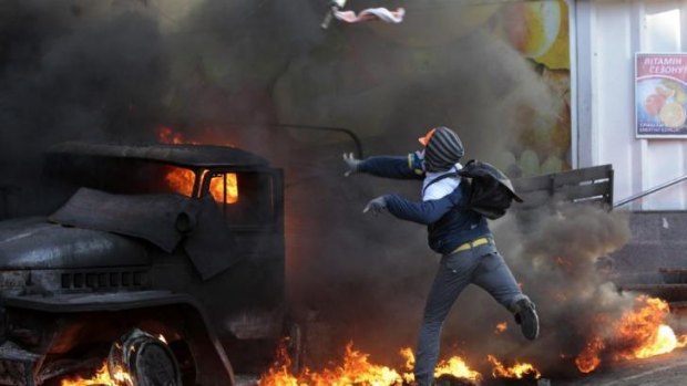 Improvised explosive ... An anti-government protester throws a Molotov's cocktail during clashes with riot police outside Ukraine's parliament in Kiev.