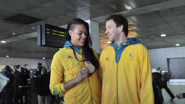 Australian basketballers Liz Cambage and Joe Ingles arrive home from the London Olympics yesterday.