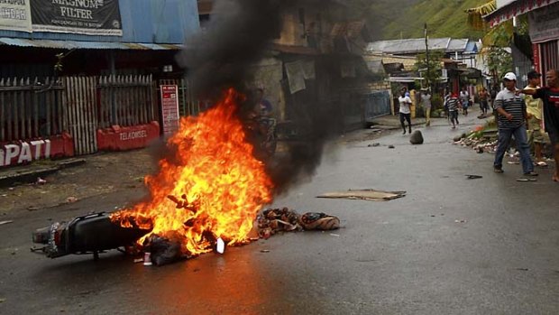 A motorcycle is set ablaze during the riot in Waena.