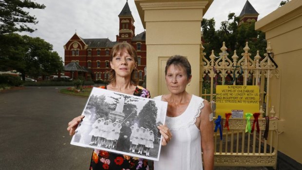 Gabby Short and Wendy Eldridge with a photo of the orphanage girls with paedophile priest Gerald Ridsdale.