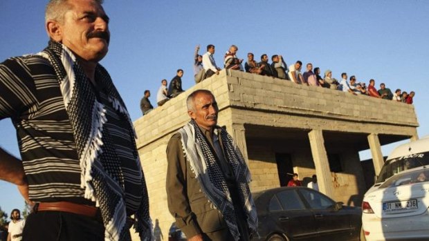 Turkish and Syrian Kurds watch the fighting for the Syrian town of Kobane (also known as Ayn al-Arab) from a vantage point on the Turkish side of the border.