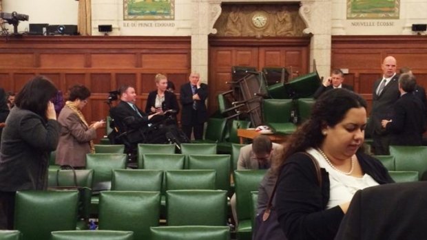 MPs block the door with chairs during a caucus meeting on Parliament Hill in Ottawa.