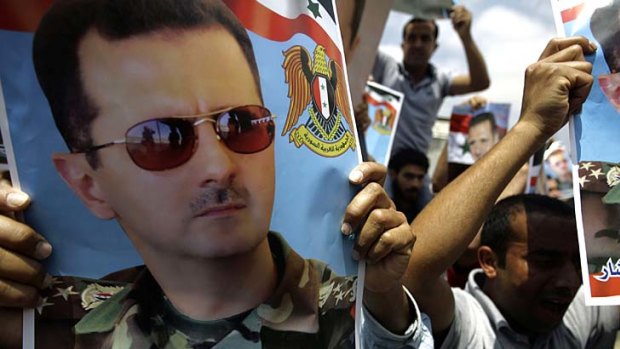Divided nation ... Syrians show their support for President Bashar al-Assad.