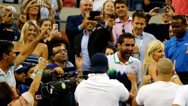 Marin Cilic celebrates in the players' box after his US Open triumph.