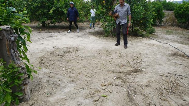A man stands at the lemon grove where Ingrid Visser and her partner Lodewijk Severein were discovered. The couple's dismembered bodies were found buried in a grave about 50 centimetres deep.