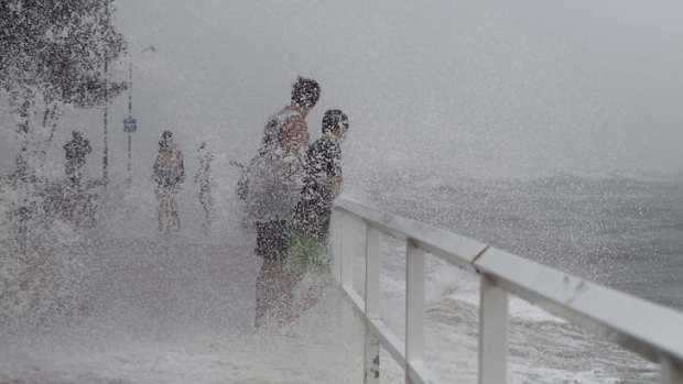 Locals at Shorncliffe Pier near Brisbane check out the storm surge during the cyclonic conditions affecting the coast of Queensland and northern New South Wales on Sunday.