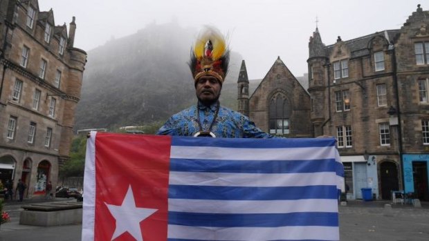 Benny Wenda flies the West Papuan flag in the shadow of Edinburgh Castle.