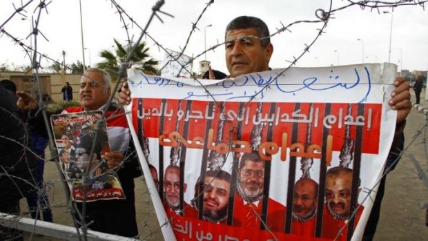 People protest against ousted president Mohamed Mursi outside the court.