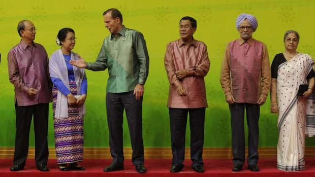 President of Myanmar Thein Sein and his wife Khin Khin Win, Prime Minister Tony Abbott, Cambodian Prime Minister Hun Sen, Indian Prime Minister Manmohan Singh and his wife Gursharan Kaur, during a group photo at the East Asia Summit in Brunei.