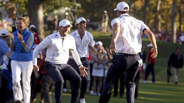 Germany's Martin Kaymer celebrates with European teammates Sergio Garcia and Rory McIlroy after his winning putt.