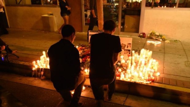 Two men kneel at a makeshift memorial after a killing rampage in Isla Vista near Santa Barbara.