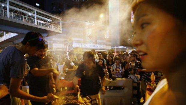 A man cooks sausages for protesters, who are blocking the main street to the financial Central district, outside the government headquarters in Hong Kong.