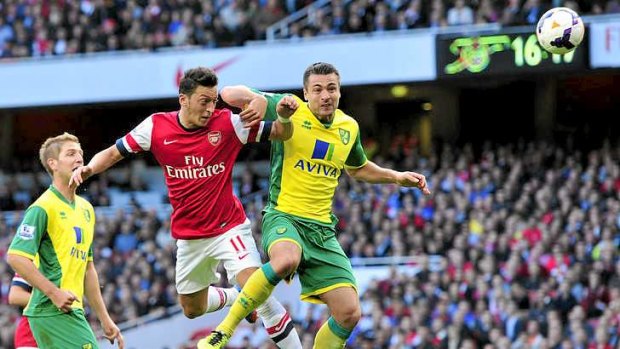 Arsenal midfielder Mesut Ozil scores the first of two goals against Norwich City.
