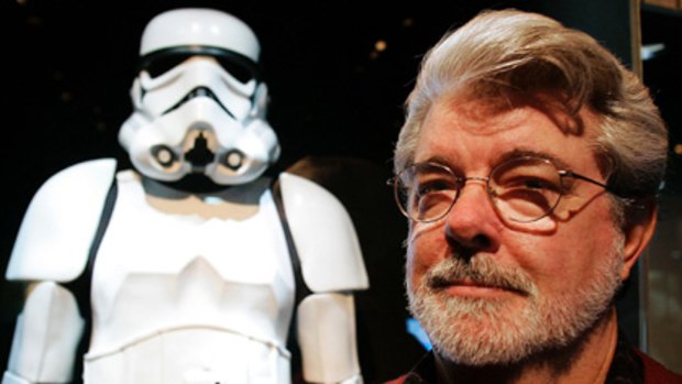 George Lucas stands in front of a stormtrooper suit.