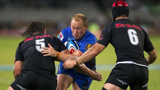 Brett Sheehan of the Force is tackled by Anton Bresler (left) and Jacques Botes of the Sharks.