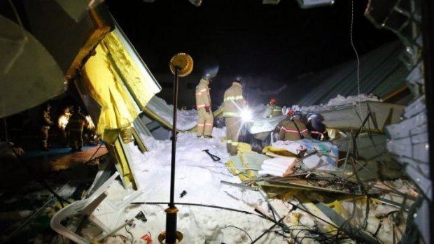 Search: Rescue workers look for survivors in the collapsed building.