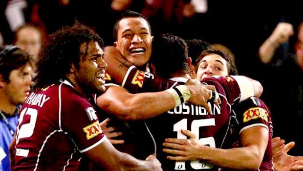 Smiles all round . . . Maroons winger Israel Folau is swamped after scoring one of his two tries last night.